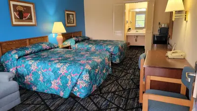 a hotel room with two beds and a desk at Guest Keeper Inn in Van Wert