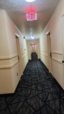 an empty hallway with a exit sign on the ceiling at Guest Keeper Inn in Van Wert