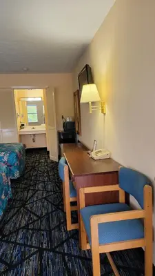 a hotel room with a desk and chairs in a room at Guest Keeper Inn in Van Wert