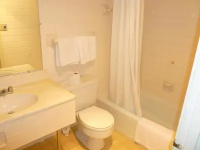 a bathroom with a toilet and a sink and a tub at Guest Keeper Inn in Van Wert
