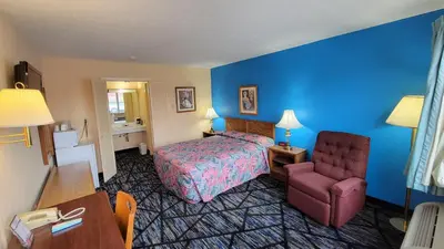 a hotel room with a bed and a chair at Guest Keeper Inn in Van Wert