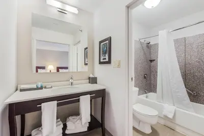a white bathroom with a sink and a toilet at The Blu Hotel Blue Ash Cincinnati, an Ascend Collection Hotel in Blue Ash