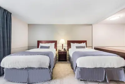 a hotel room with two beds and a lamp at The Blu Hotel Blue Ash Cincinnati, an Ascend Collection Hotel in Blue Ash
