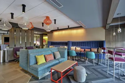 a lobby with a couch and tables and chairs at Tru By Hilton Mason King's Island in Mason