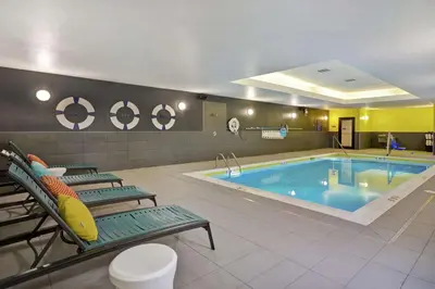 a pool in a hotel room with two chairs and a poolificialificialificialificial at Tru By Hilton Mason King's Island in Mason