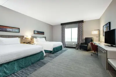 a hotel room with two beds and a flat screen tv at Hilton Garden Inn Pittsburgh Area Beaver Valley, Pa in Monaca