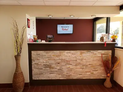 a fireplace in a waiting room with a tv above it at Red Roof Inn Wheelersburg in Wheelersburg