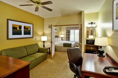 a hotel room with a couch and a bed at Country Inn & Suites by Radisson, Marion, OH in Marion