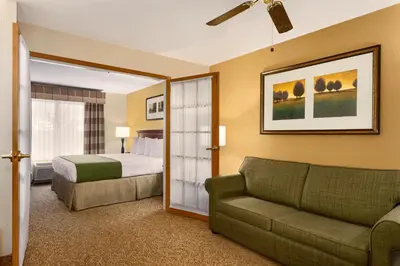 a hotel room with a bed and a couch and a bed at Country Inn & Suites by Radisson, Marion, OH in Marion