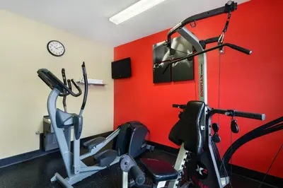 a gym with two exercise bikes and a red wall at Country Inn & Suites by Radisson, Marion, OH in Marion