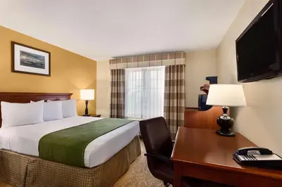 a hotel room with a bed and a desk with a computer at Country Inn & Suites by Radisson, Marion, OH in Marion