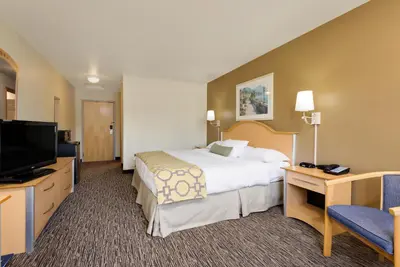 a hotel room with a bed and a flat screen tv at Baymont by Wyndham Lawrenceburg in Lawrenceburg