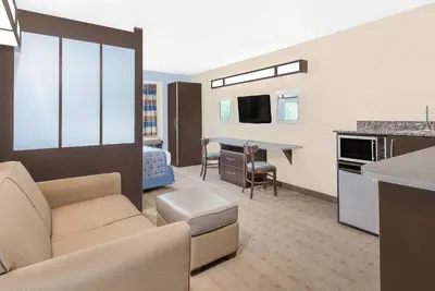 a living room with a couch and a dining room at Microtel Inn & Suites by Wyndham Waynesburg in Waynesburg