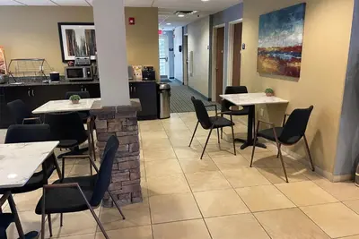 a restaurant with tables and chairs in a room at Microtel Inn & Suites by Wyndham Waynesburg in Waynesburg