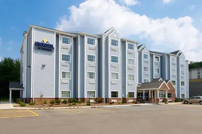 a large white building with a hotel sign on it at Microtel Inn & Suites by Wyndham Waynesburg in Waynesburg