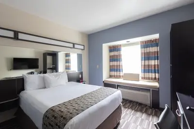a hotel room with a large bed and a window at Microtel Inn & Suites by Wyndham Waynesburg in Waynesburg