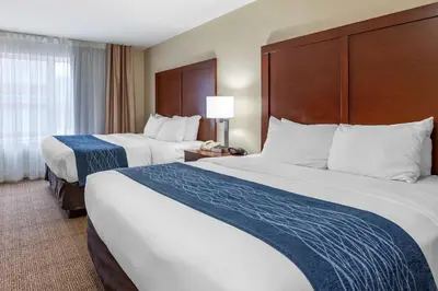 a hotel room with two beds and a window at Comfort Inn & Suites Northern Kentucky in Wilder