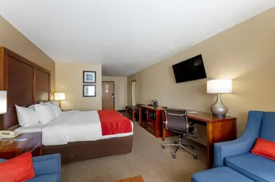 a hotel room with a bed and a desk and chair at Comfort Inn River's Edge in Huron
