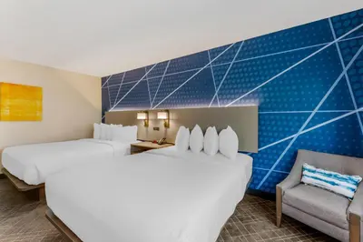a hotel room with two beds and a chair at Comfort Inn River's Edge in Huron