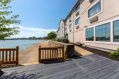 a boardwalk next to a building next to a body of water at Comfort Inn River's Edge in Huron