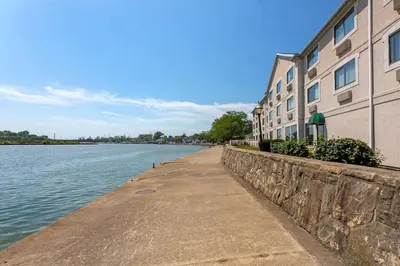 a sidewalk next to a building next to a body of water at Comfort Inn River's Edge in Huron