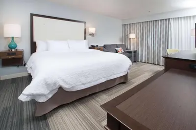 a hotel room with a large bed and a desk at Hampton Inn Tiffin in Tiffin