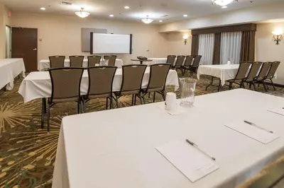 a conference room with tables and chairs and a screen at Hampton Inn Tiffin in Tiffin