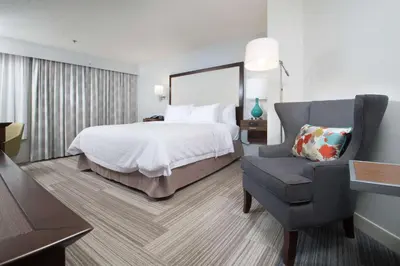 a hotel room with a bed and a chair at Hampton Inn Tiffin in Tiffin