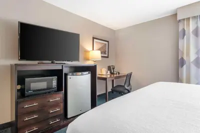 a hotel room with a bed and a flat screen tv at Best Western St. Clairsville Inn & Suites in Saint Clairsville
