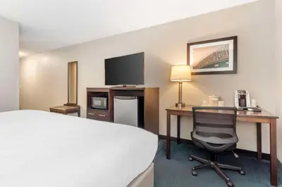 a hotel room with a bed and a desk with a computer at Best Western St. Clairsville Inn & Suites in Saint Clairsville