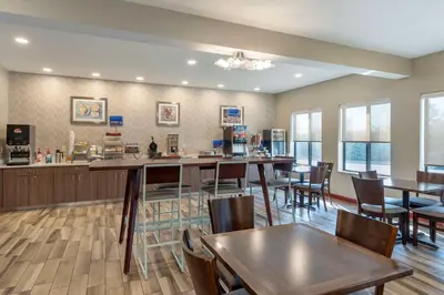 a restaurant with tables and chairs and a bar at Best Western St. Clairsville Inn & Suites in Saint Clairsville