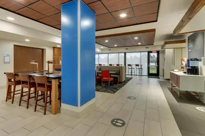 an office lobby with a blue pillar in the middle of the room at Holiday Inn Express & Suites Troy by IHG in Troy
