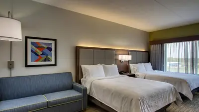 a hotel room with two beds and a couch at Holiday Inn Express & Suites Troy by IHG in Troy