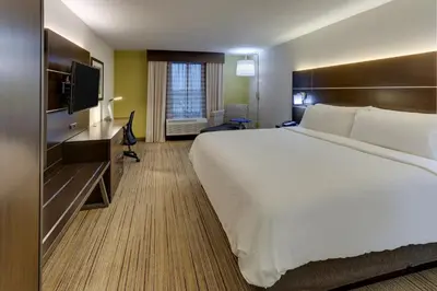 a hotel room with a large bed and a television at Holiday Inn Express & Suites Troy by IHG in Troy