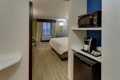 a hotel room with a bed and a television at Holiday Inn Express & Suites Troy by IHG in Troy