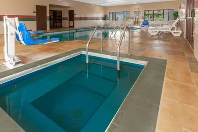 a pool in a gym with a swimming pool at Days Inn by Wyndham Milan Sandusky South in Milan