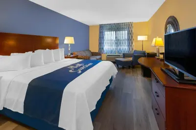 a hotel room with a large bed and a flat screen tv at Days Inn by Wyndham Milan Sandusky South in Milan