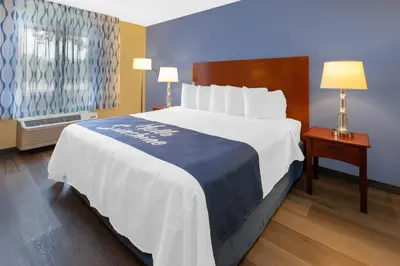 a hotel room with a large bed and a window at Days Inn by Wyndham Milan Sandusky South in Milan
