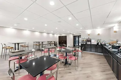 a restaurant with black tables and red chairs at Comfort Suites Columbus in Columbus