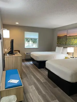 a hotel room with two beds and a television at Days Inn by Wyndham Lisbon in Lisbon