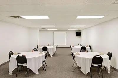 a conference room with white tables and chairs and a whiteboard at Days Inn by Wyndham Lisbon in Lisbon