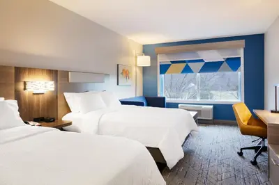 a hotel room with two beds and a desk and a window at Holiday Inn Express Hotel & Suites Van Wert by IHG in Van Wert