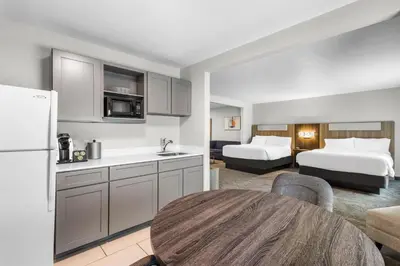 a kitchen and living room with two beds and a table at Holiday Inn Express Hotel & Suites Van Wert by IHG in Van Wert