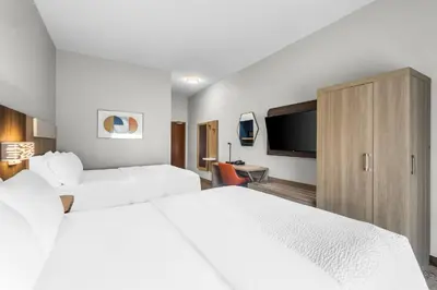 a hotel room with two beds and a flat screen tv at Holiday Inn Express Hotel & Suites Van Wert by IHG in Van Wert