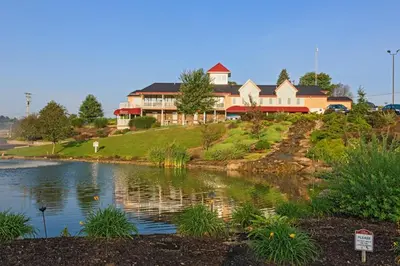 a large house on a hill next to a lake at Berlin Resort in Millersburg