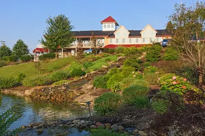 a large house on a hill next to a river at Berlin Resort in Millersburg