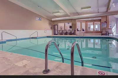 a large swimming pool with blue water in a building at Berlin Resort in Millersburg