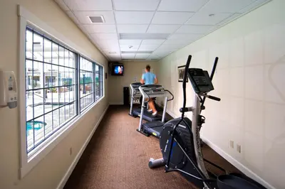 a gym with exercise bikes and a person in the background at Carlisle Inn in Sugarcreek