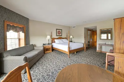 a living room with a bed and a couch at Carlisle Inn in Sugarcreek