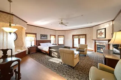 a bedroom with a bed and a living room at Carlisle Inn in Sugarcreek